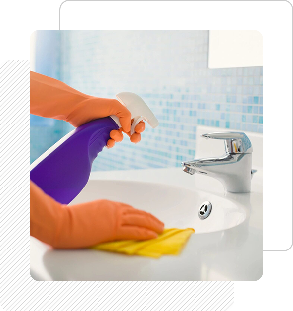A person cleaning the bathroom sink with an orange glove.